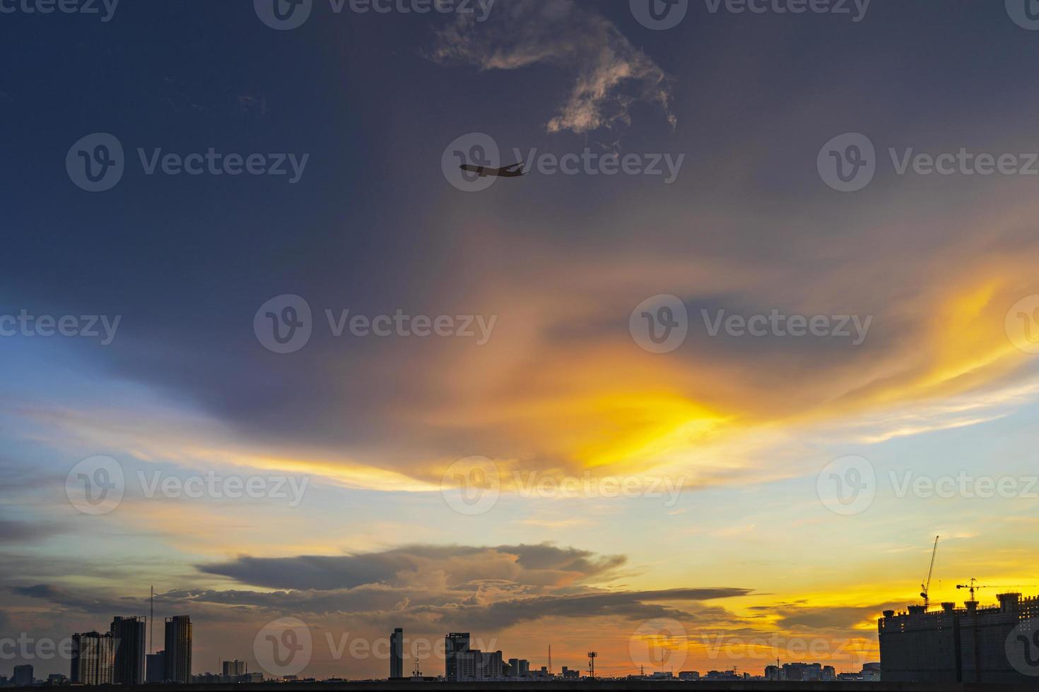 silhueta de Bangkok ao pôr do sol com avião voando no céu crepuscular foto