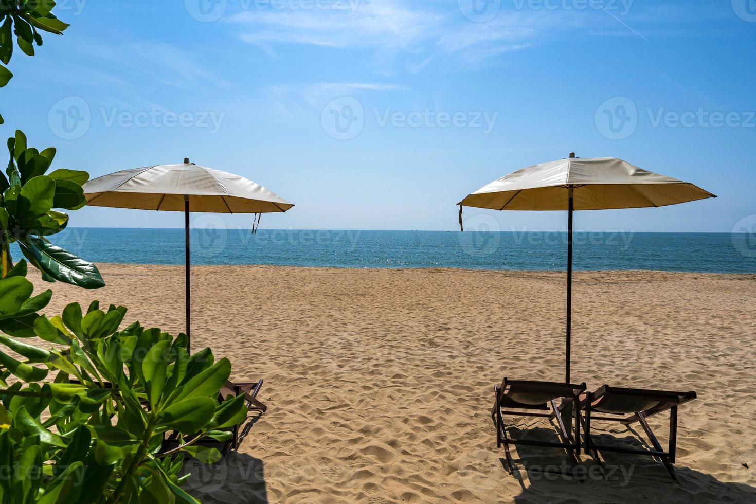 praia tropical com guarda-sol sob as palmeiras na luz do sol, plano de fundo de férias foto