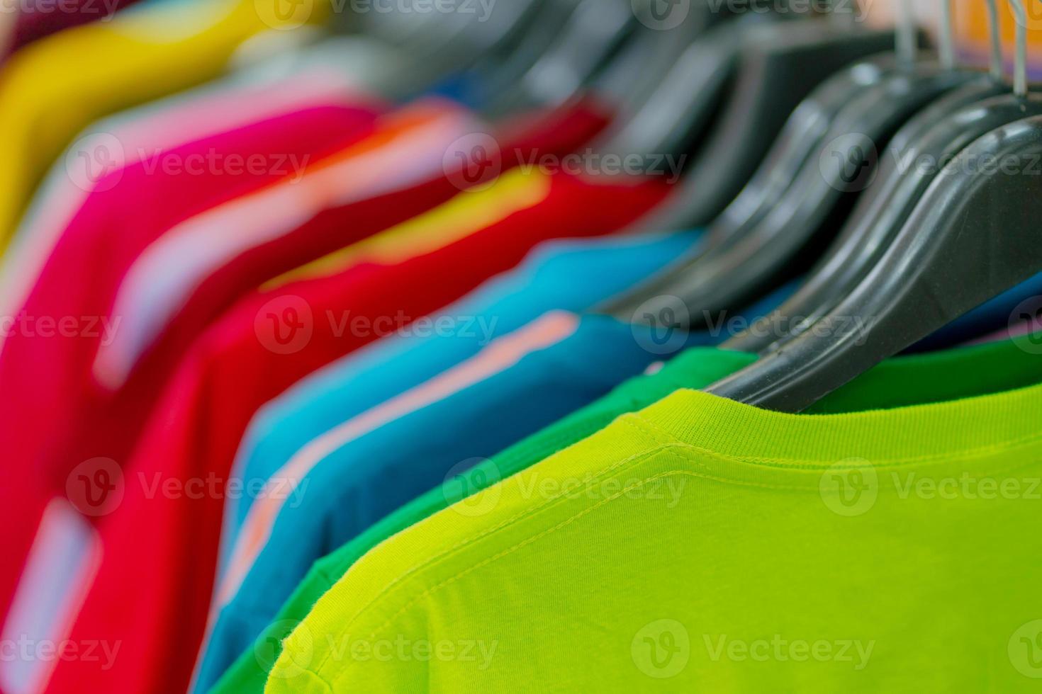 close up de camisetas coloridas em cabides foto