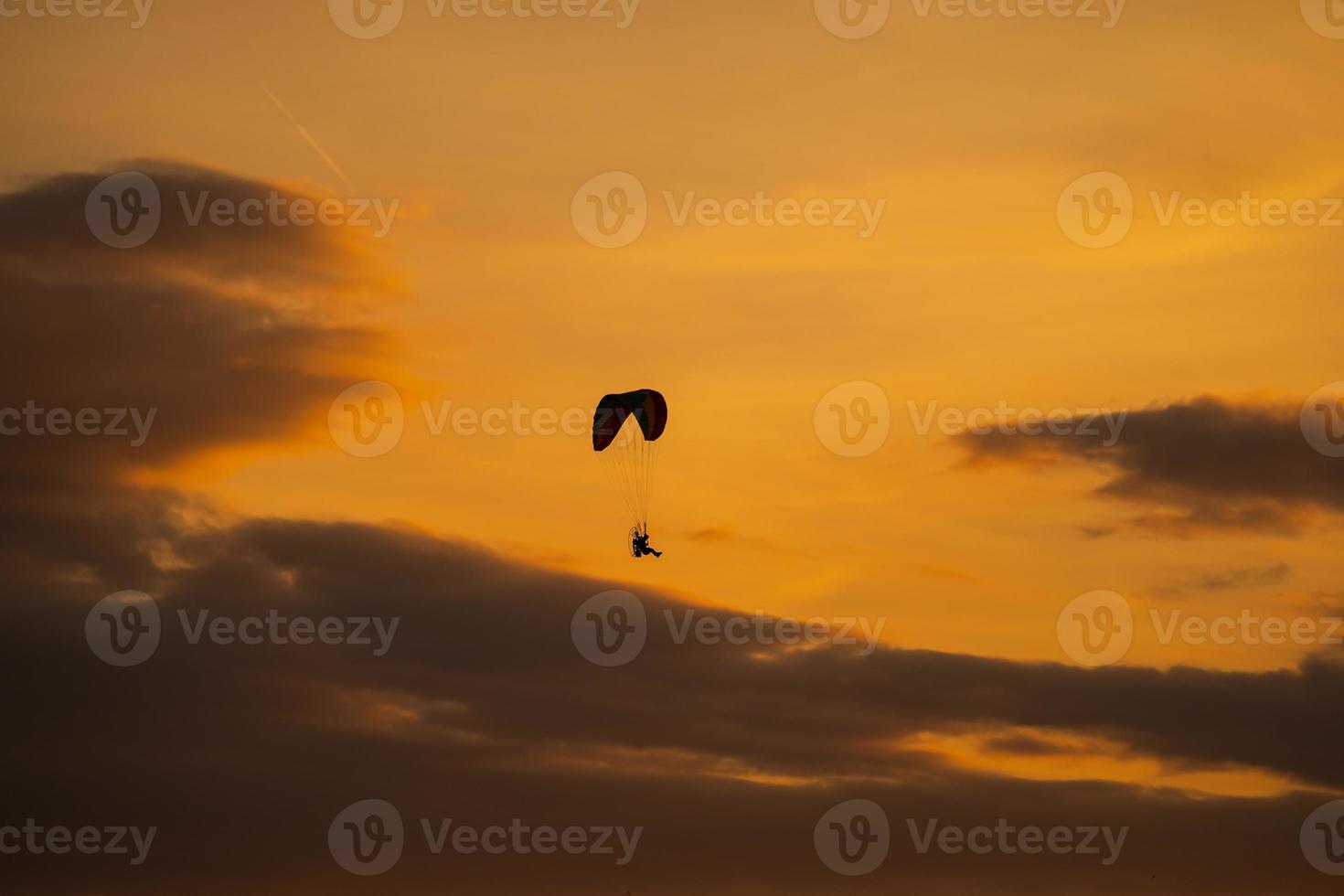 a silhueta do paramotor ao pôr do sol foto