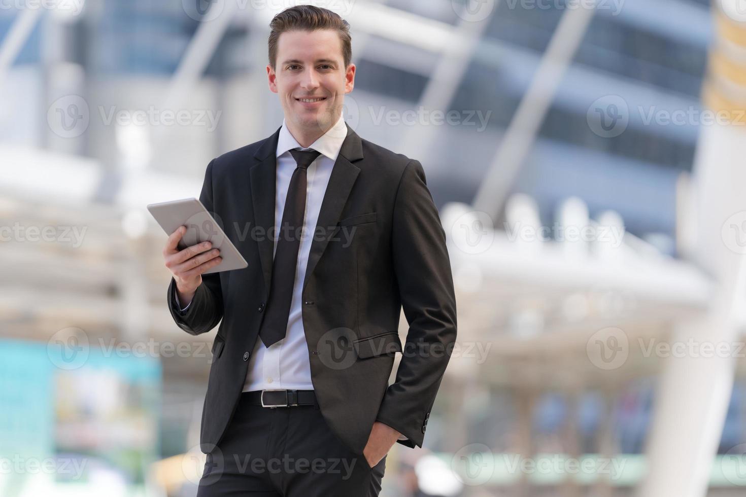 retrato de empresário sorridente, olhando para o tablet foto