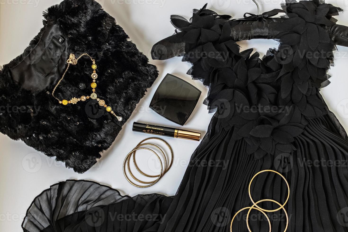 preto com flatlay dourado sobre fundo branco. roupas de festa, acessórios e cosméticos. conceito de preparação de férias foto