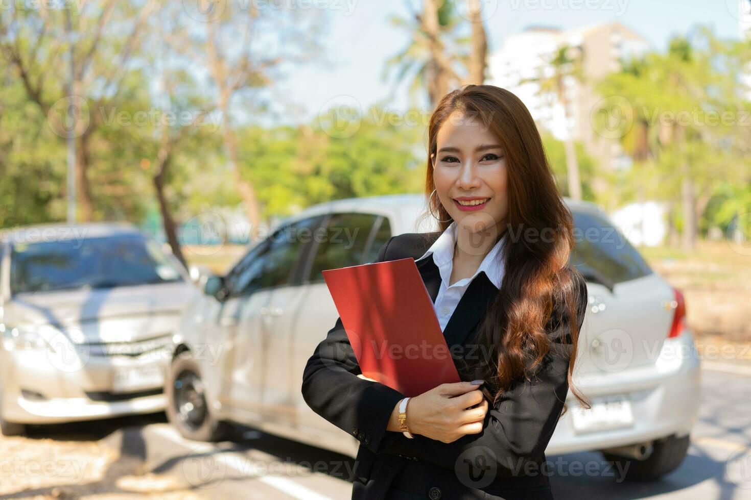 mulheres asiáticas são agentes de seguros segurando pranchetas e em pé na frente de acidentes de carro depois de verificar danos no carro, conceitos de seguro e acidentes de trânsito. foto