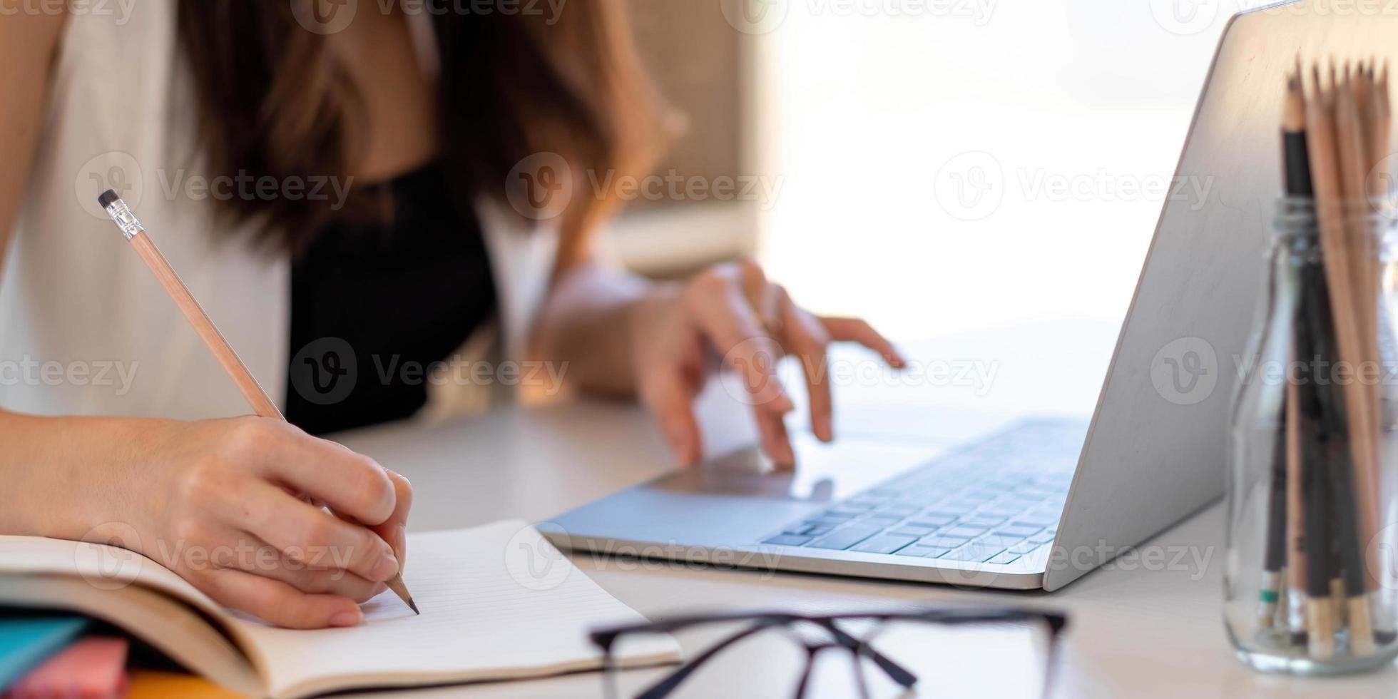feche a mão da mulher de negócios segurando uma caneta e apontando para a papelada financeira, gráficos financeiros para analisar o conceito de lucro foto