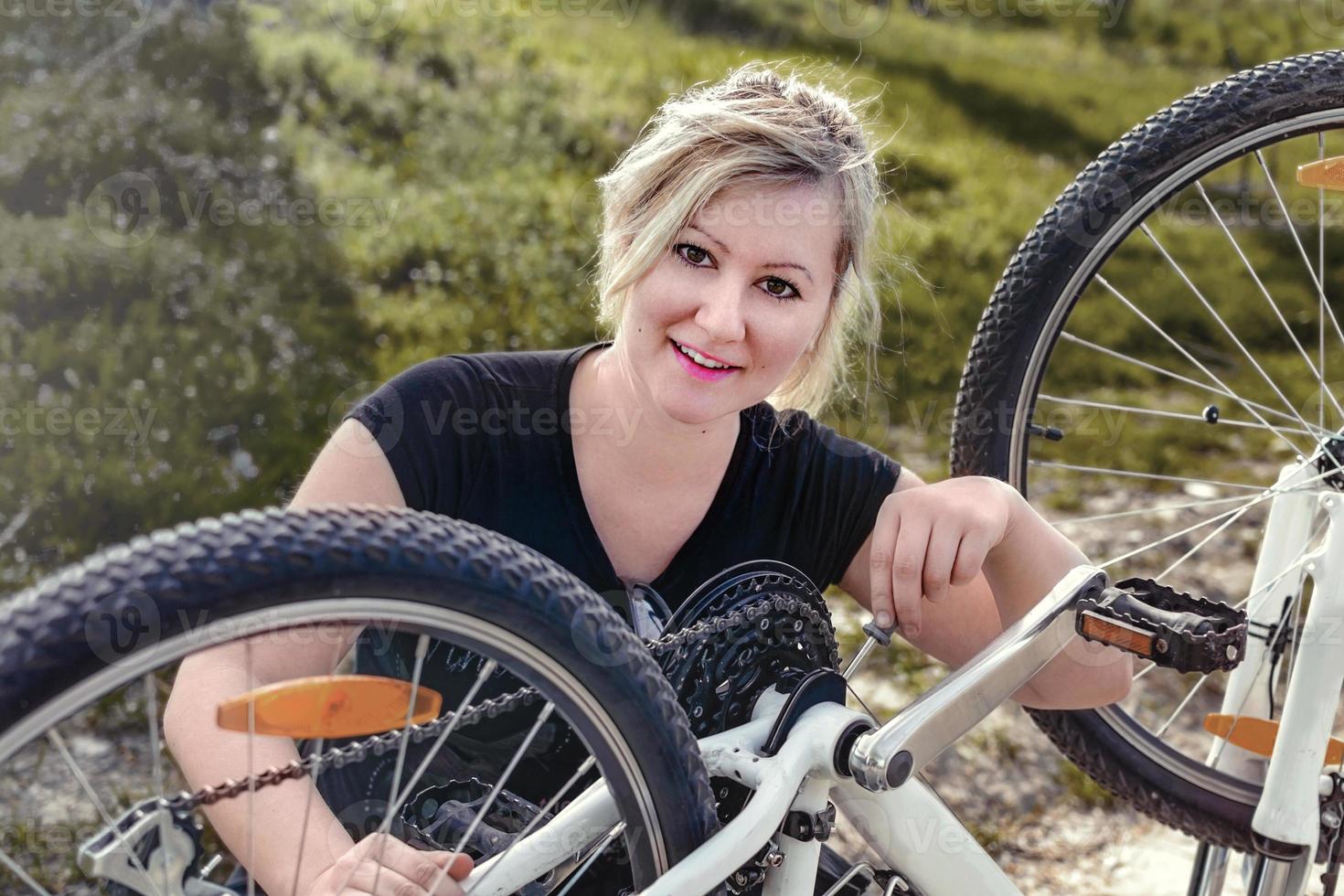 mulher conserta sua bicicleta foto