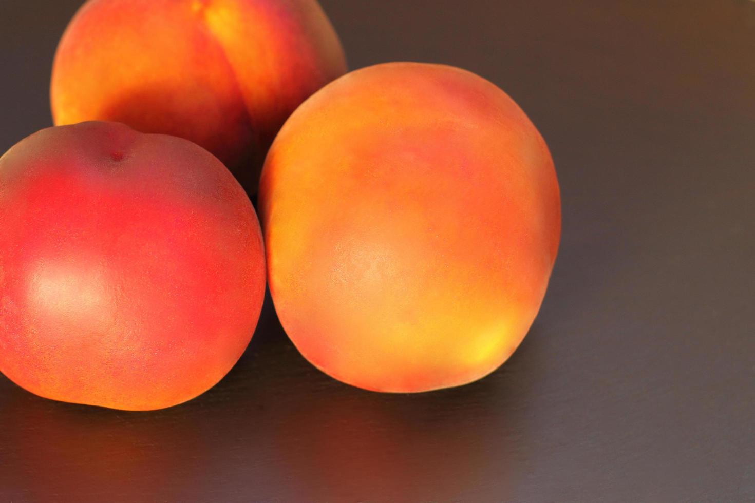 pêssego maduro, close-up de três pêssegos prunus persica em fundo preto foto