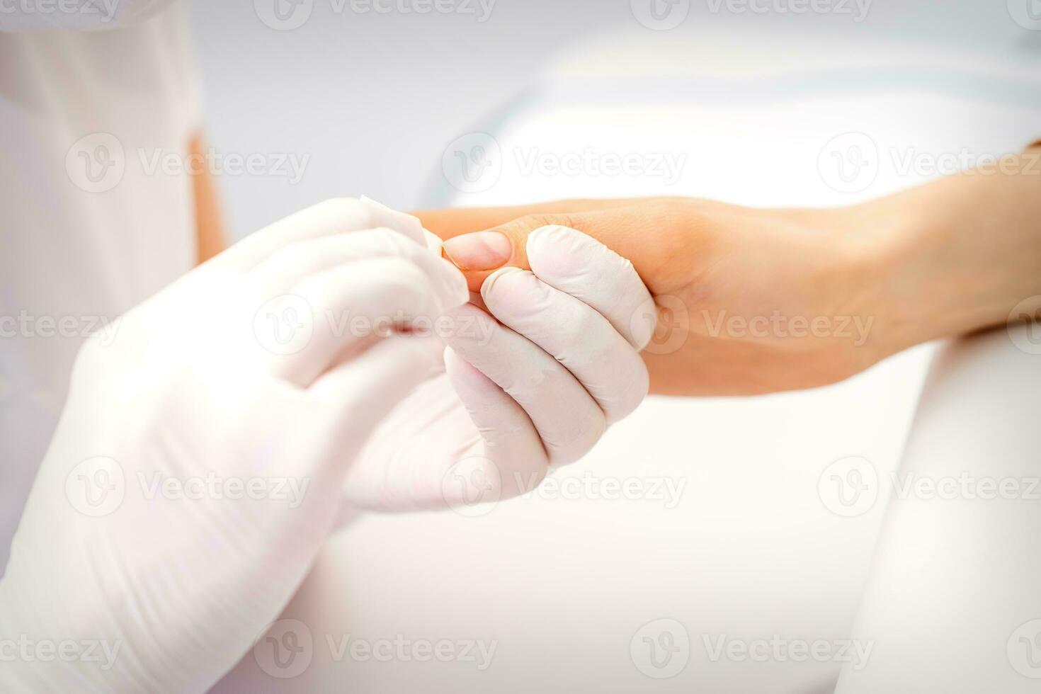 manicure mestre limpando a hidratante a partir de a fim do fêmea dedos dentro beleza salão. foto
