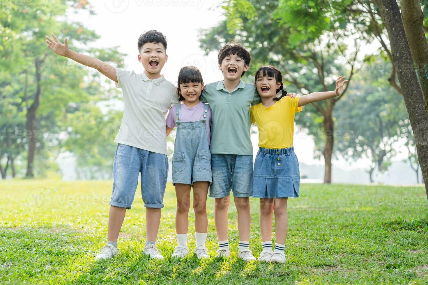 grupo do fofa ásia crianças tendo Diversão dentro a parque foto