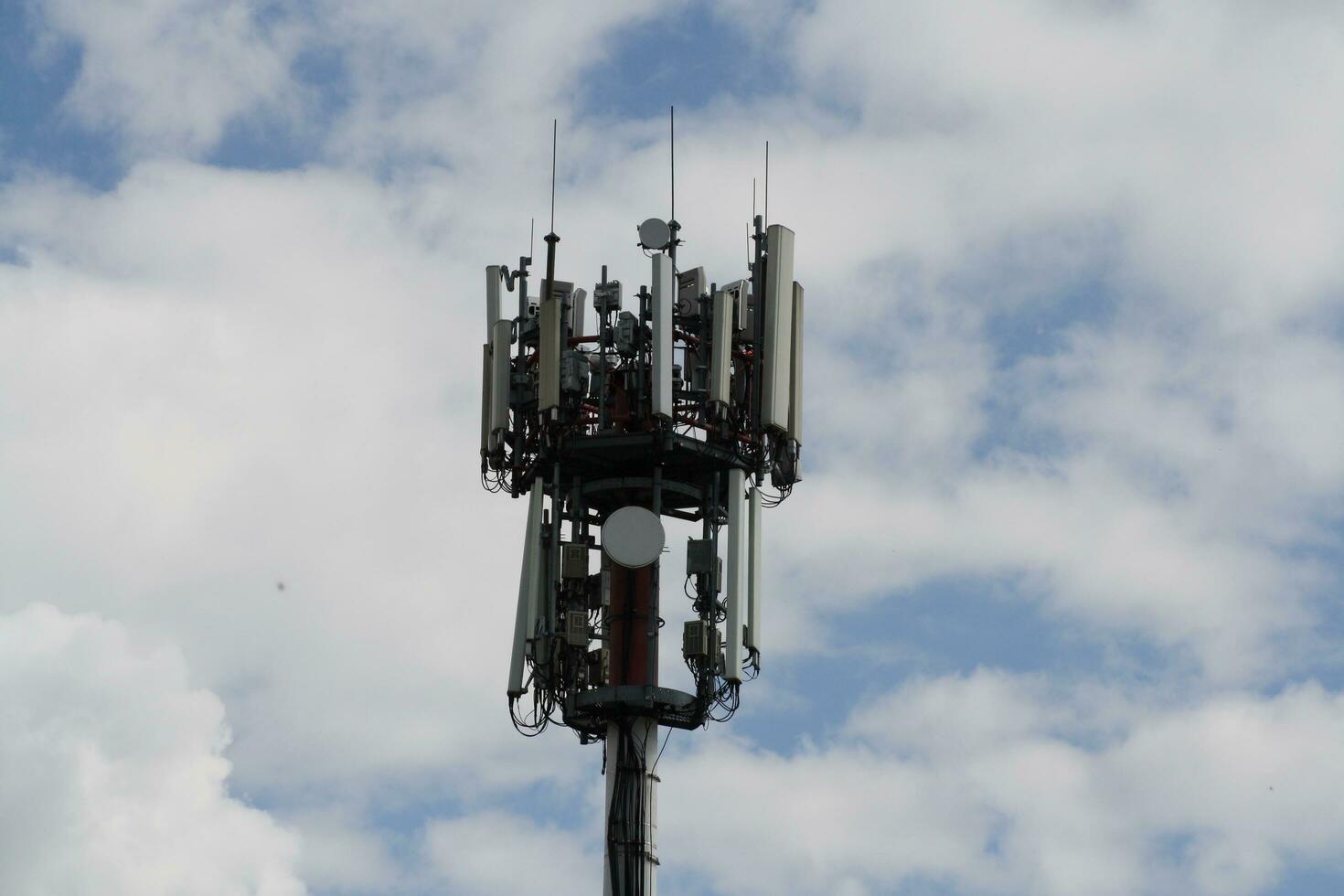 uma fechar-se do uma televisão antena e Wi-fi transmissor com nublado céu foto