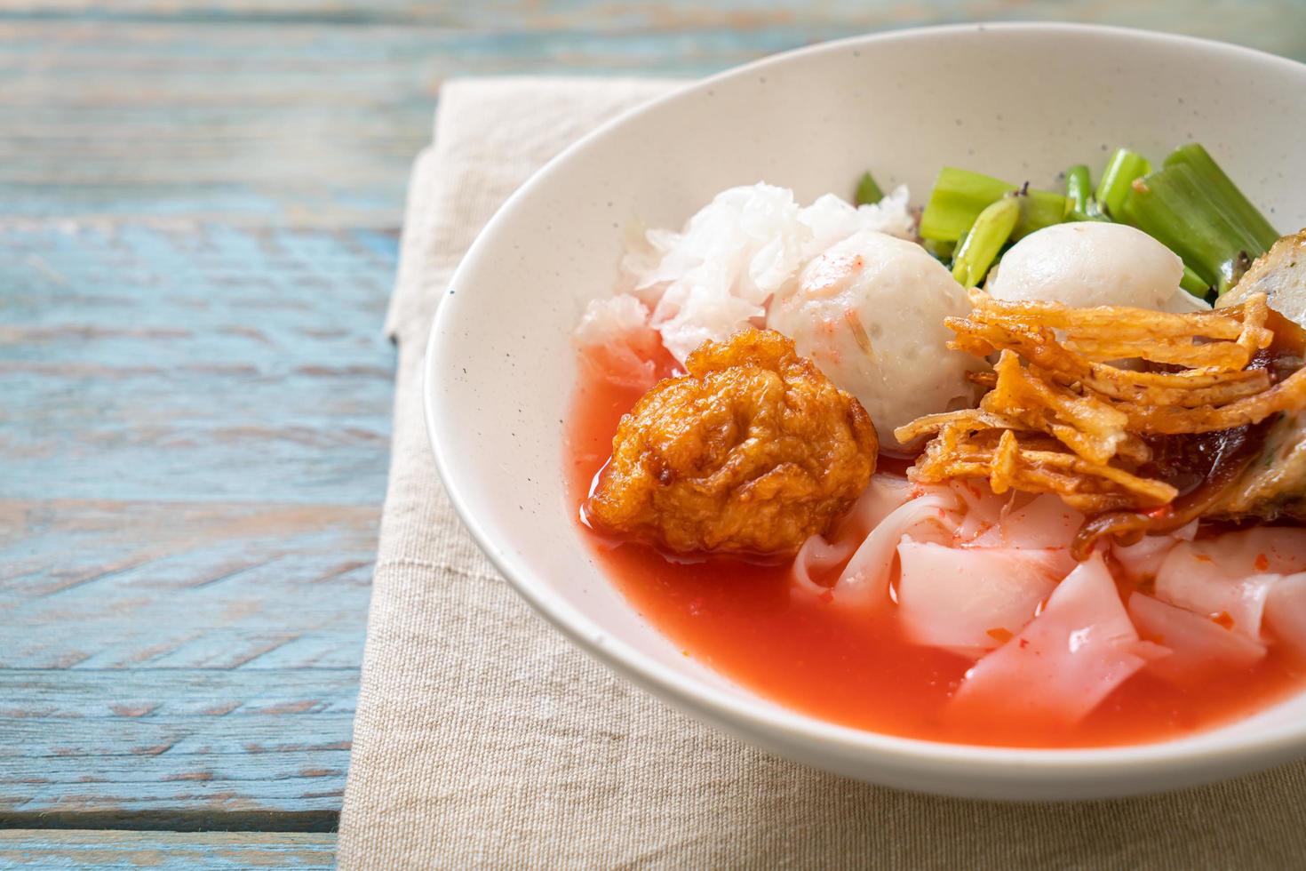 yen-ta-four - macarrão estilo tailandês com tofu variado e bolinho de peixe na sopa vermelha foto