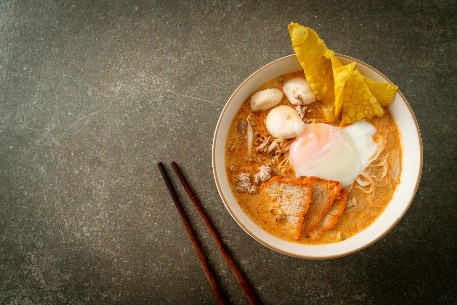 Macarrão de arroz aletria com almôndega, porco assado e ovo na sopa picante foto