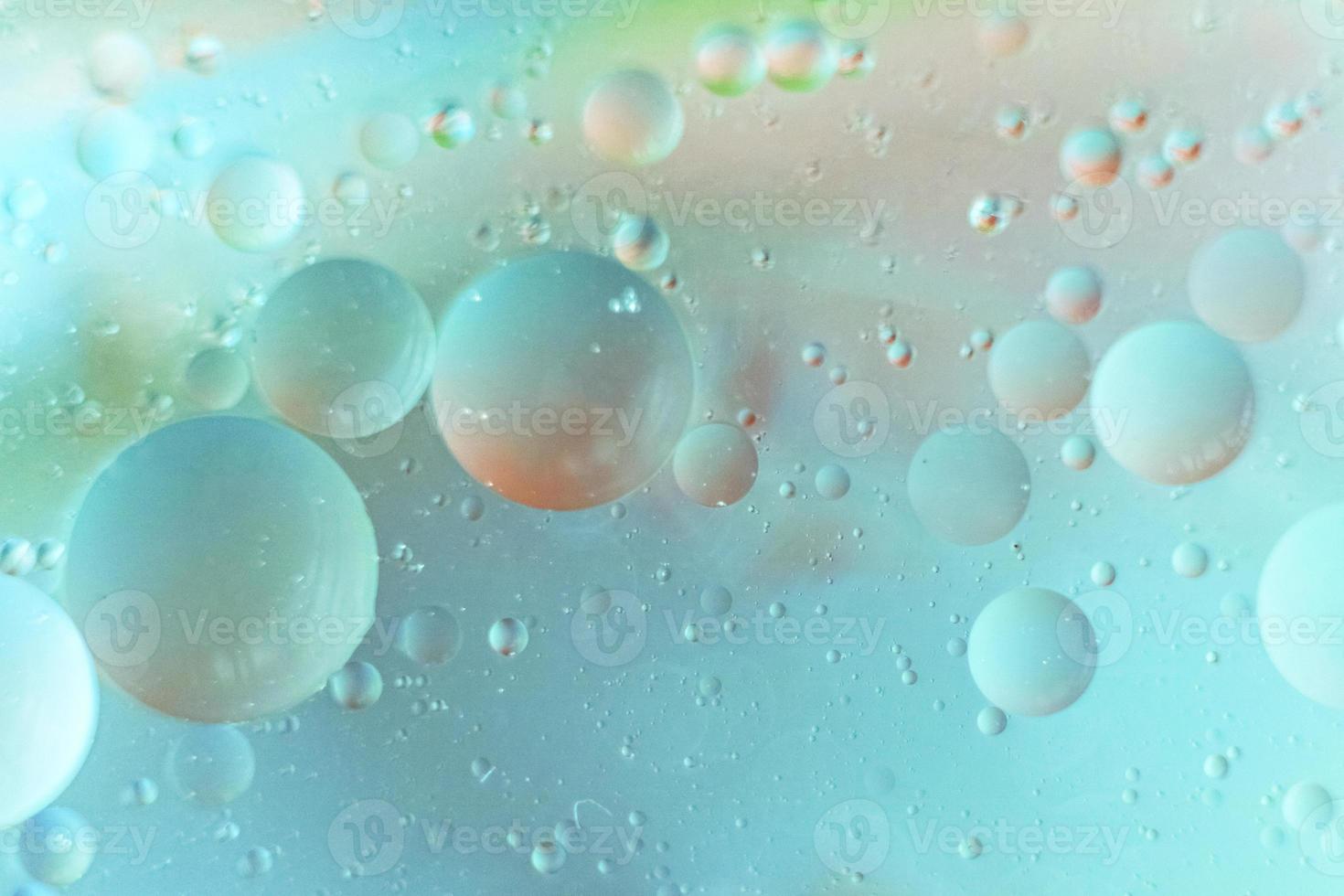 foto macro de gotas de óleo na água em um fundo verde azul desfocado