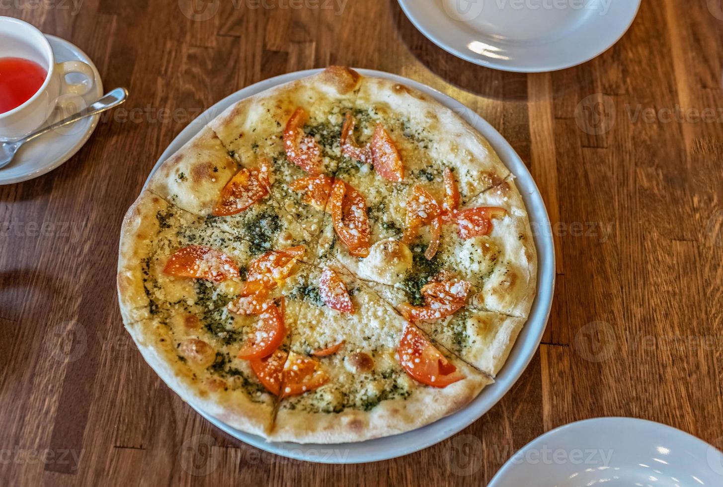 pizza quente fresca vegetariana em um prato branco. mesa servida em restaurante italiano foto