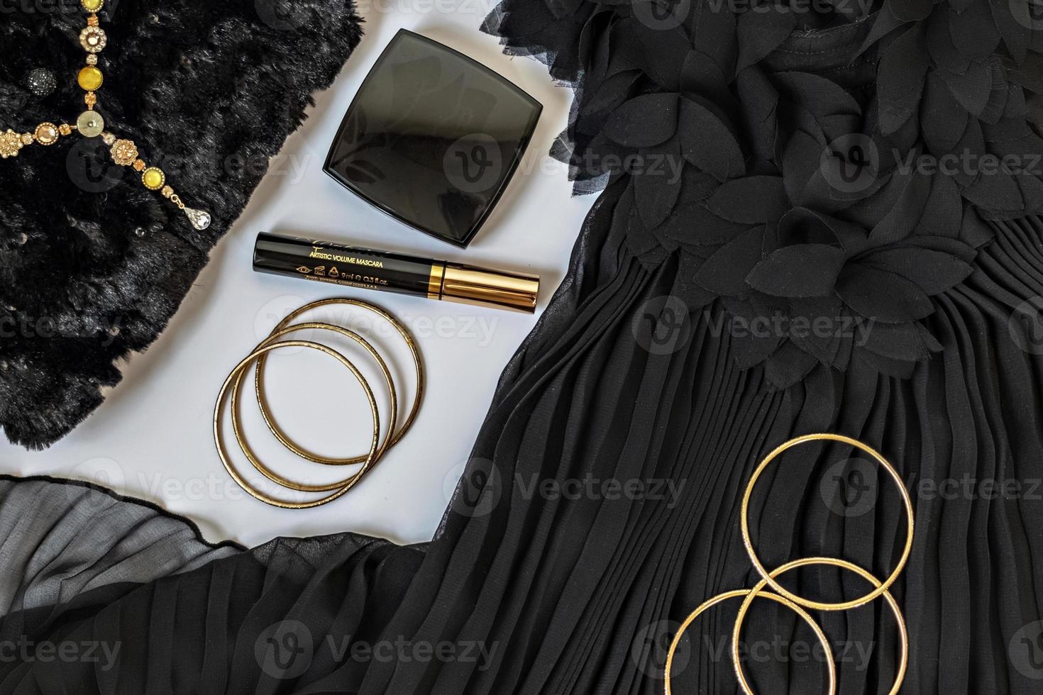 preto com flatlay dourado sobre fundo branco. roupas de festa, acessórios e cosméticos. conceito de preparação de férias foto