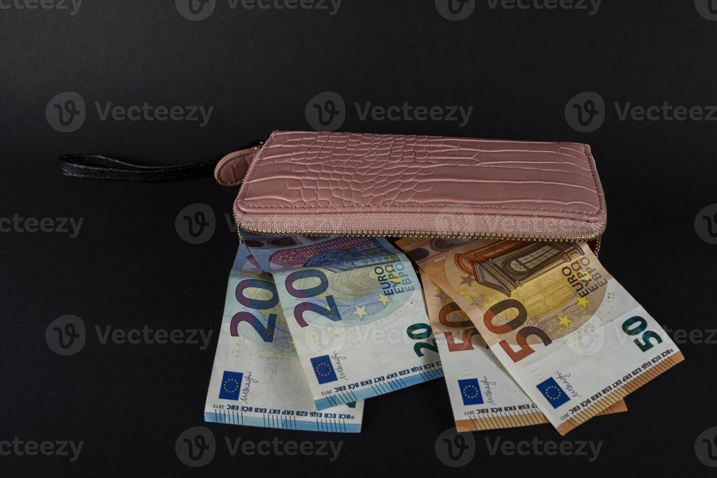 carteira feminina em cima de notas de euro foto