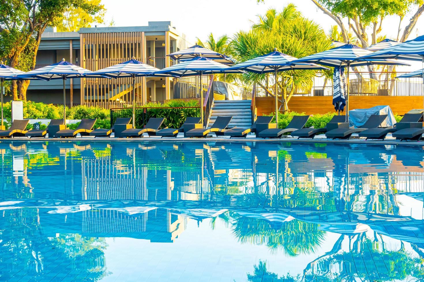 guarda-sol e cama ao redor da piscina externa em hotel resort para viagens de férias foto