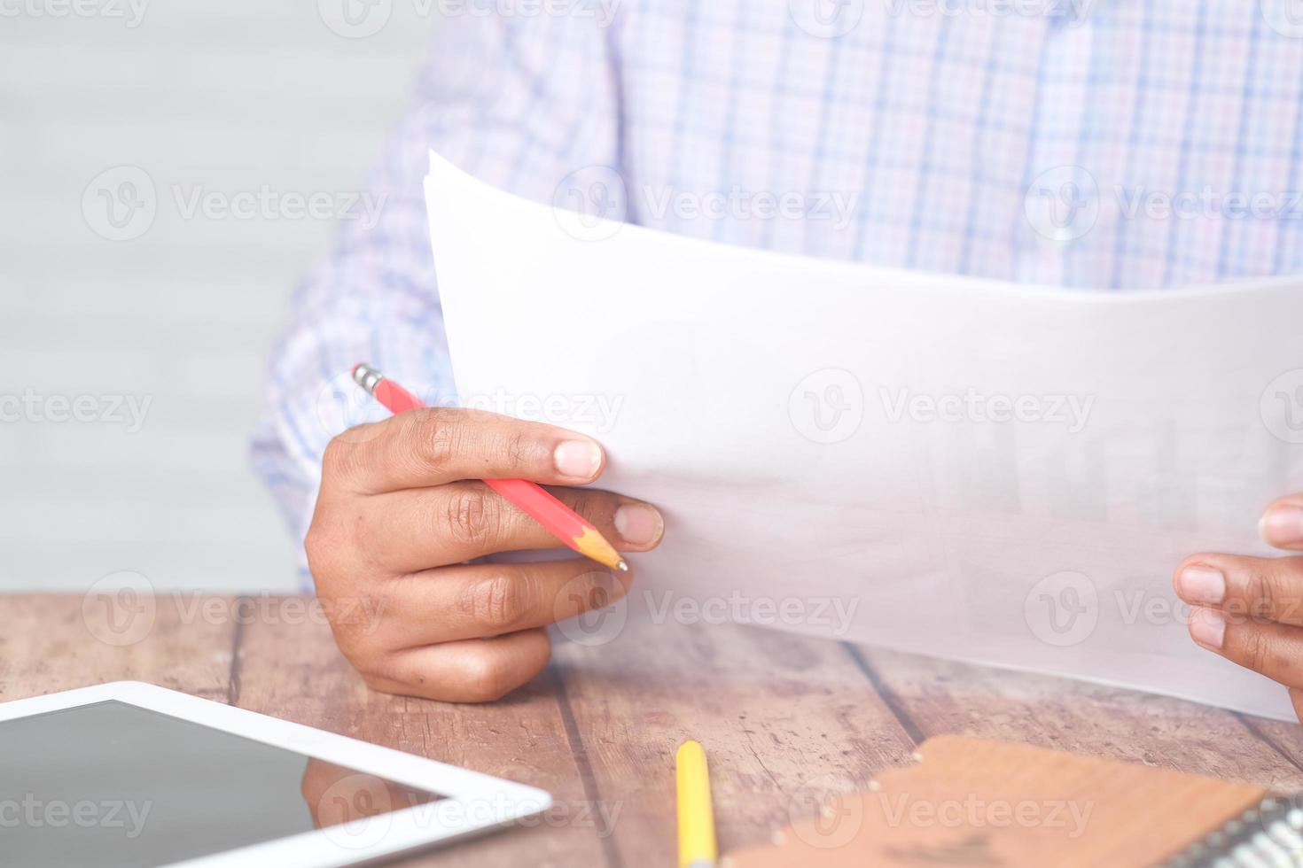 mão do homem com caneta analisando o gráfico de barras no papel foto