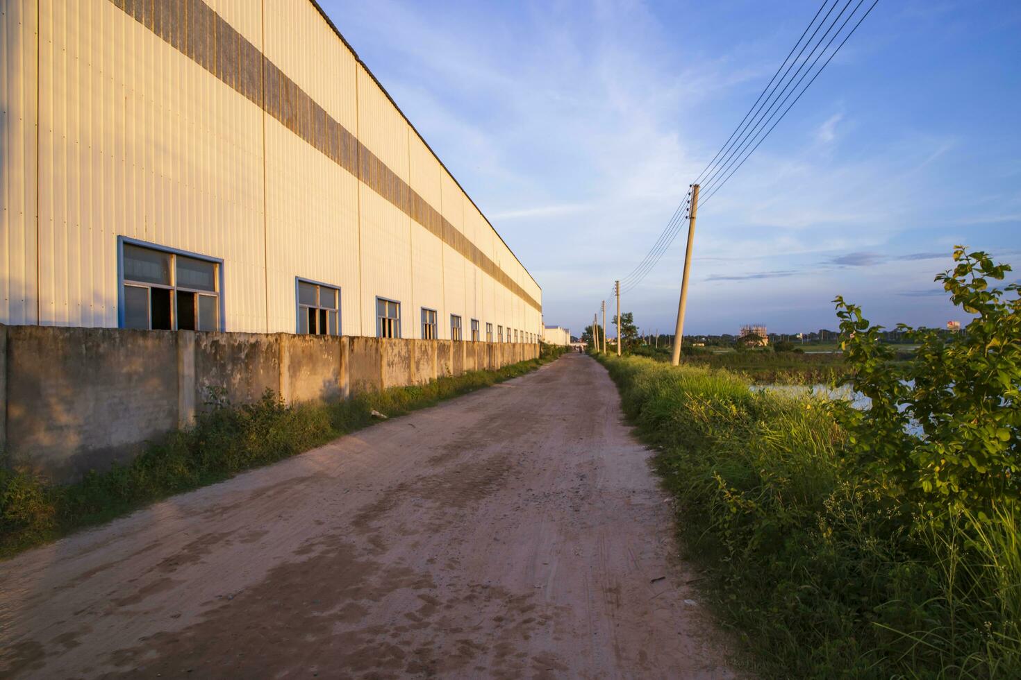 industrial tarde luz solar refletindo em a industrial armazém contra a azul céu panorama Visão foto