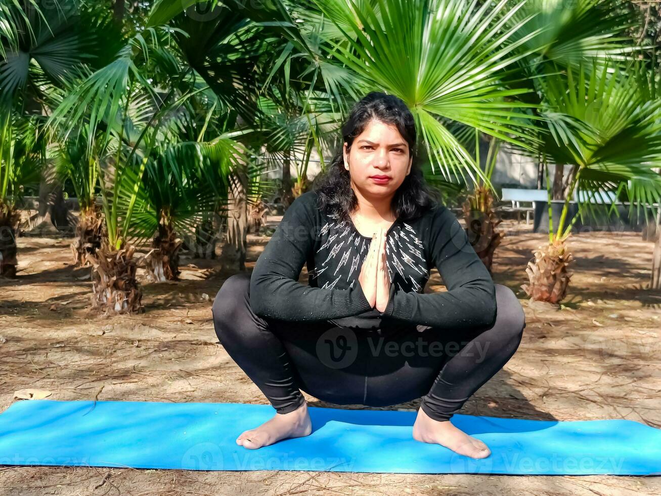 jovem indiana praticando ioga ao ar livre em um parque. linda garota pratica pose de ioga básica. calma e relaxamento, felicidade feminina. poses básicas de ioga ao ar livre foto
