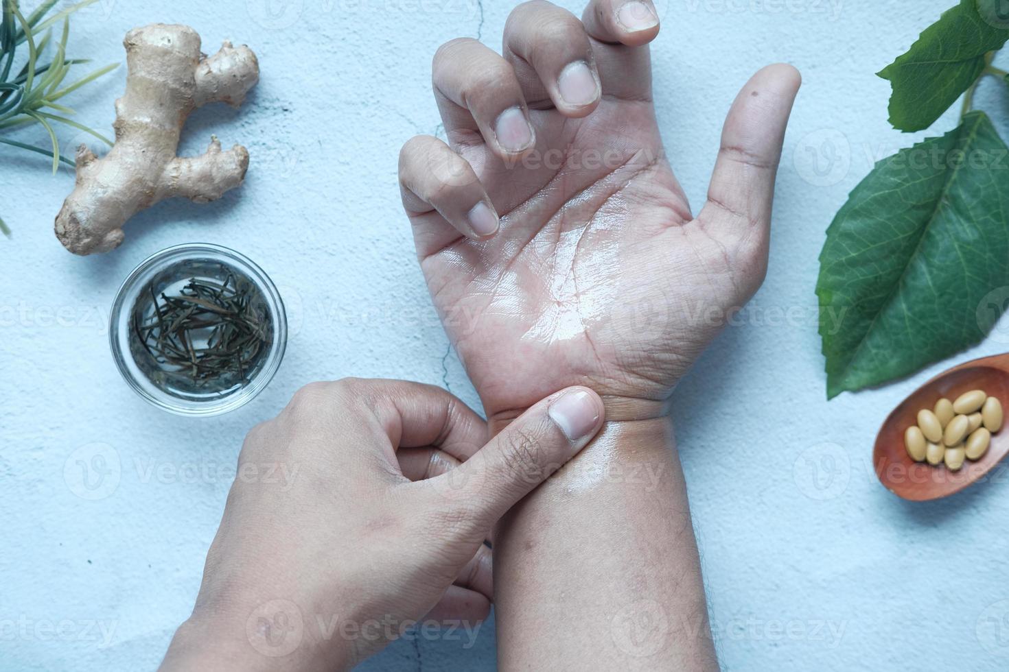 homem aplicando medicina alternativa na mão dolorida foto