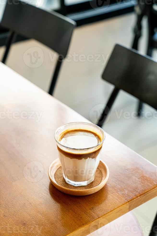 café sujo - um copo de expresso misturado com leite fresco frio foto