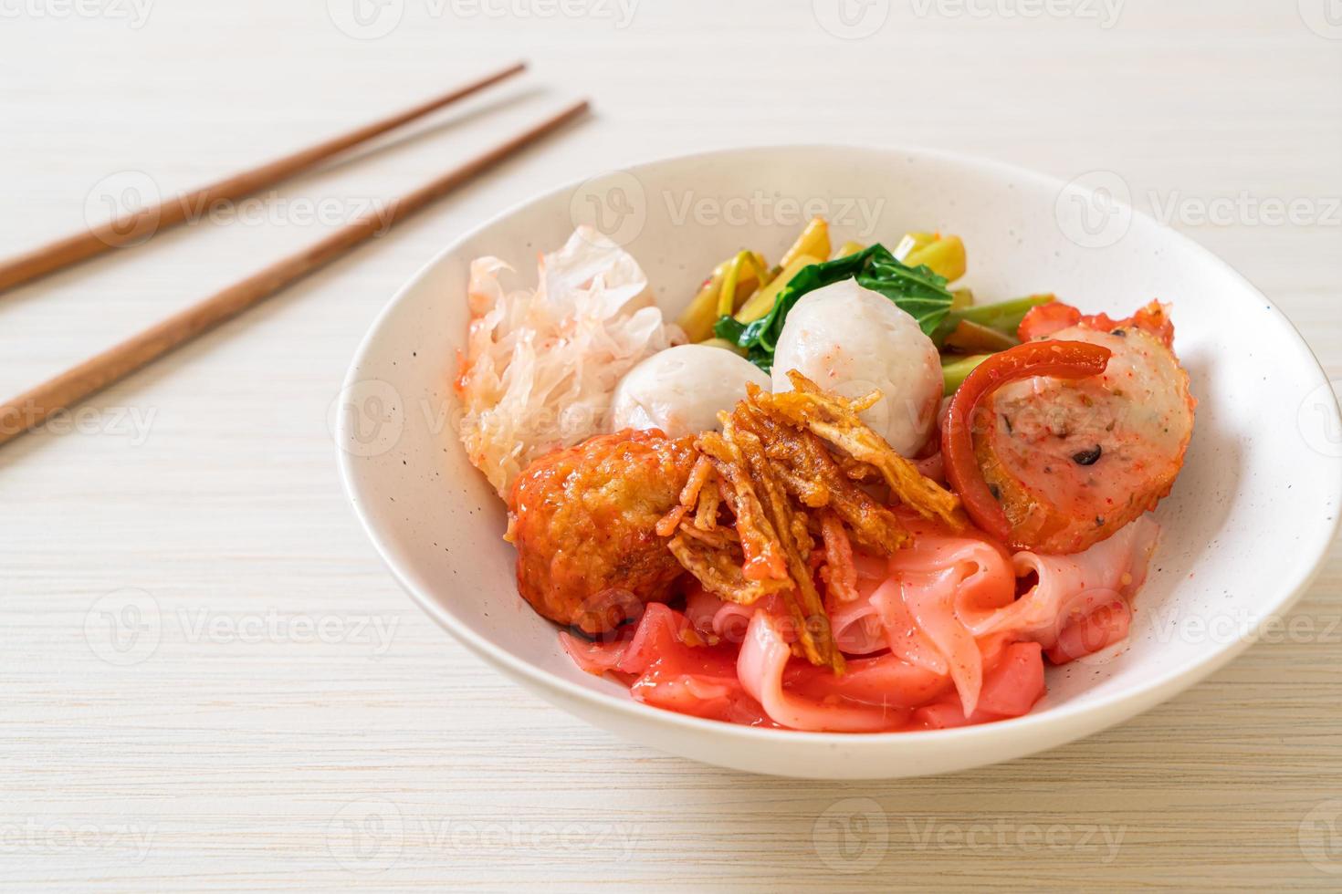 Macarrão seco à Thai com tofu variado e bolinho de peixe na sopa vermelha foto