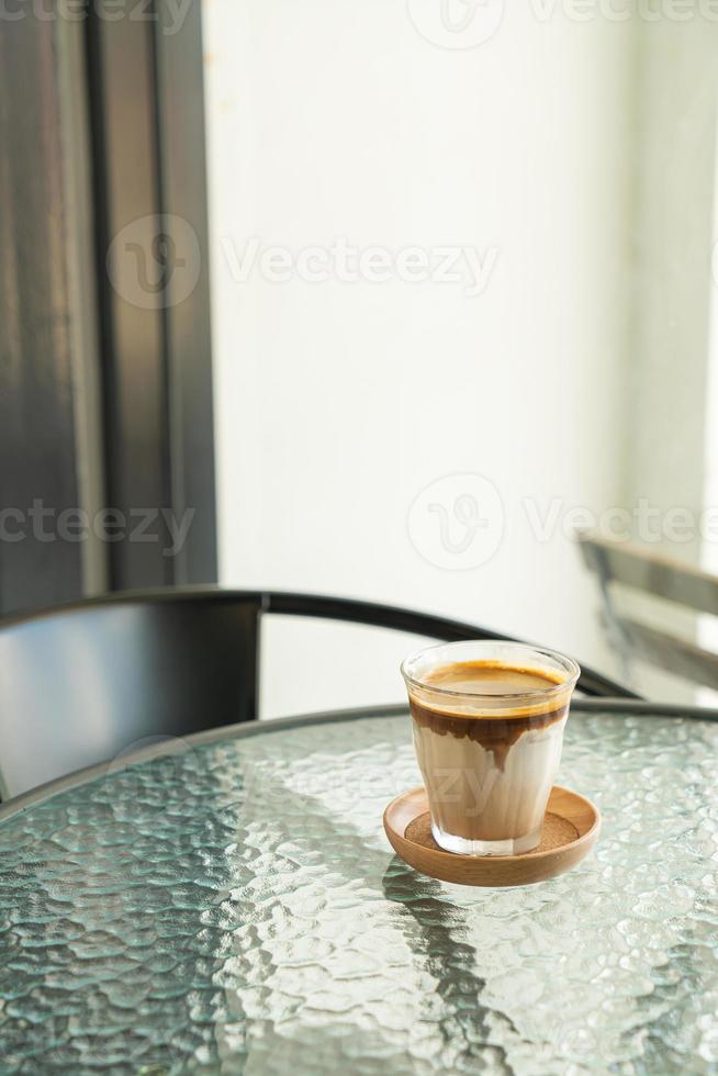 café sujo - um copo de expresso misturado com leite fresco frio foto