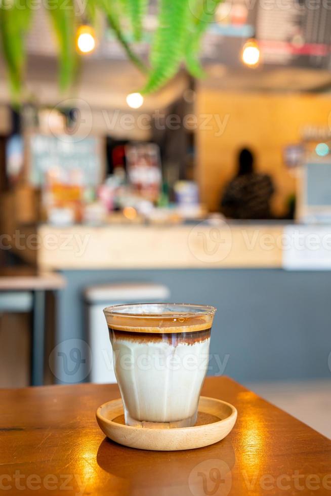 café sujo - um copo de expresso misturado com leite fresco frio foto