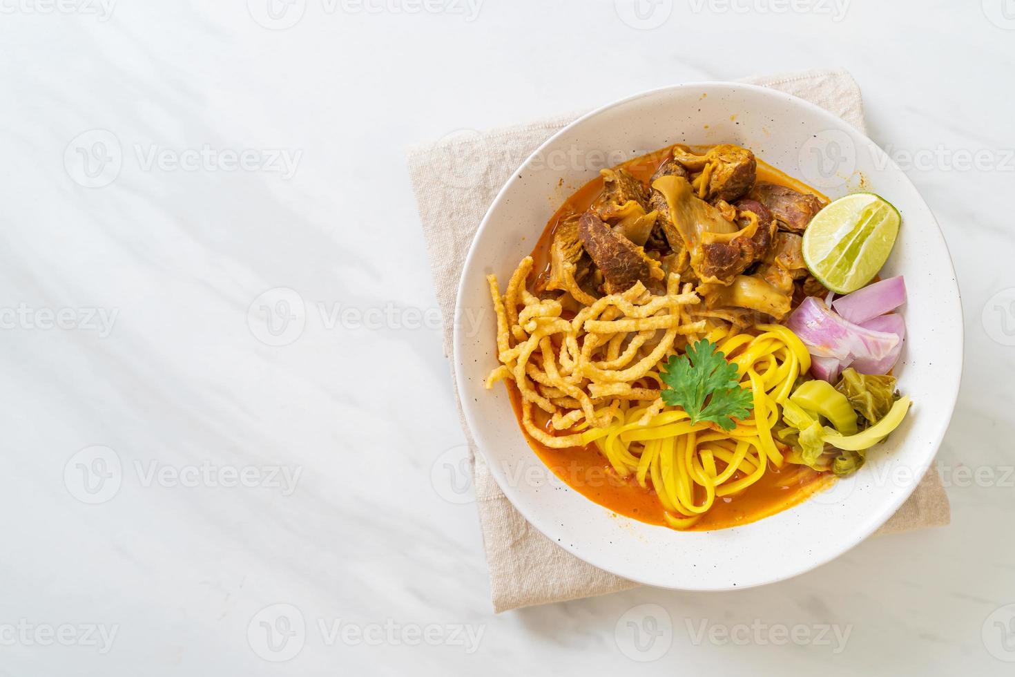 Sopa de macarrão ao norte da Tailândia com carne de porco assada foto