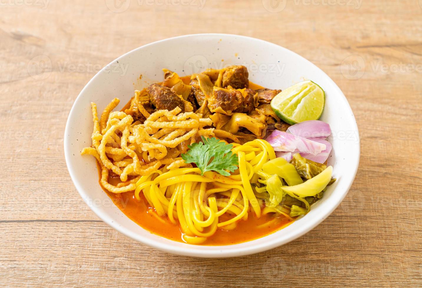 Sopa de macarrão ao norte da Tailândia com carne de porco assada foto