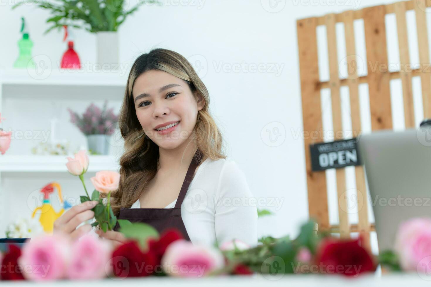 lindo ásia mulher florista segurando ramalhete do rosas dentro flor fazer compras. foto