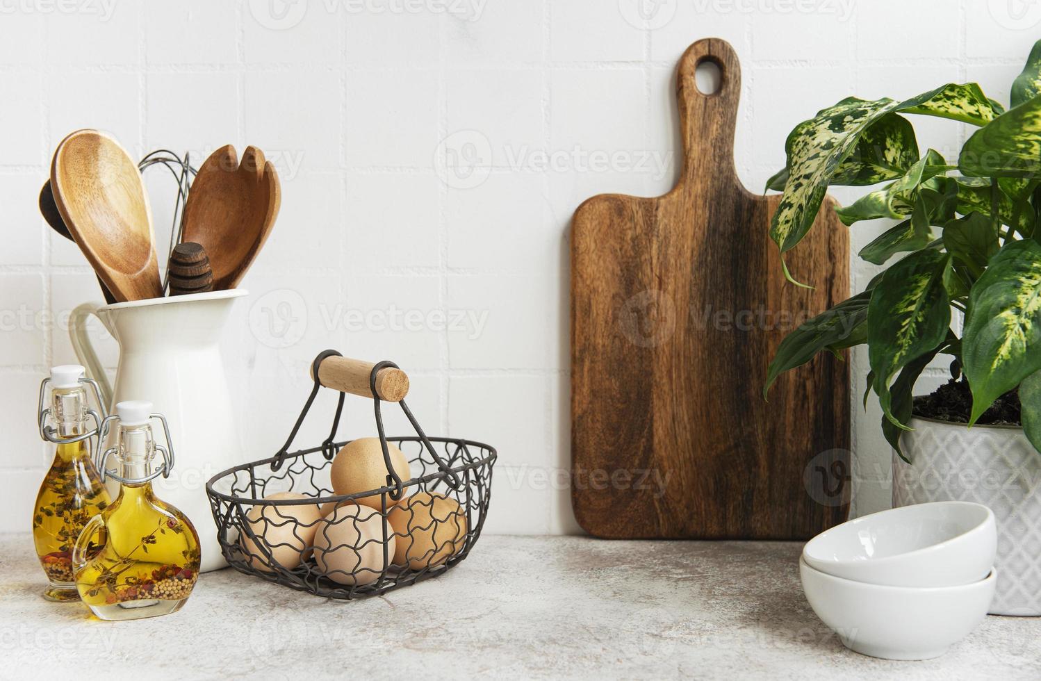 utensílios de cozinha, ferramentas e louças na parede de azulejos brancos de fundo. foto
