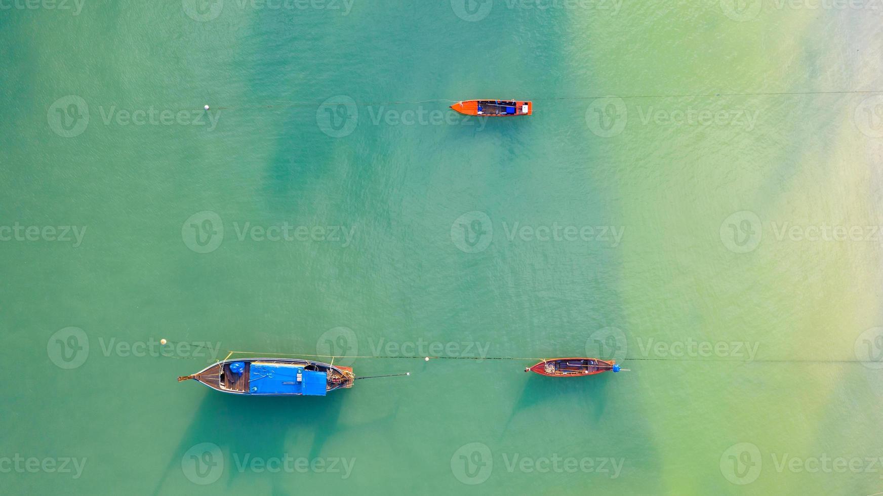 vista aérea de cima, barco de pesca, barco turístico flutuando em um mar raso e claro, linda água azul brilhante no oceano foto