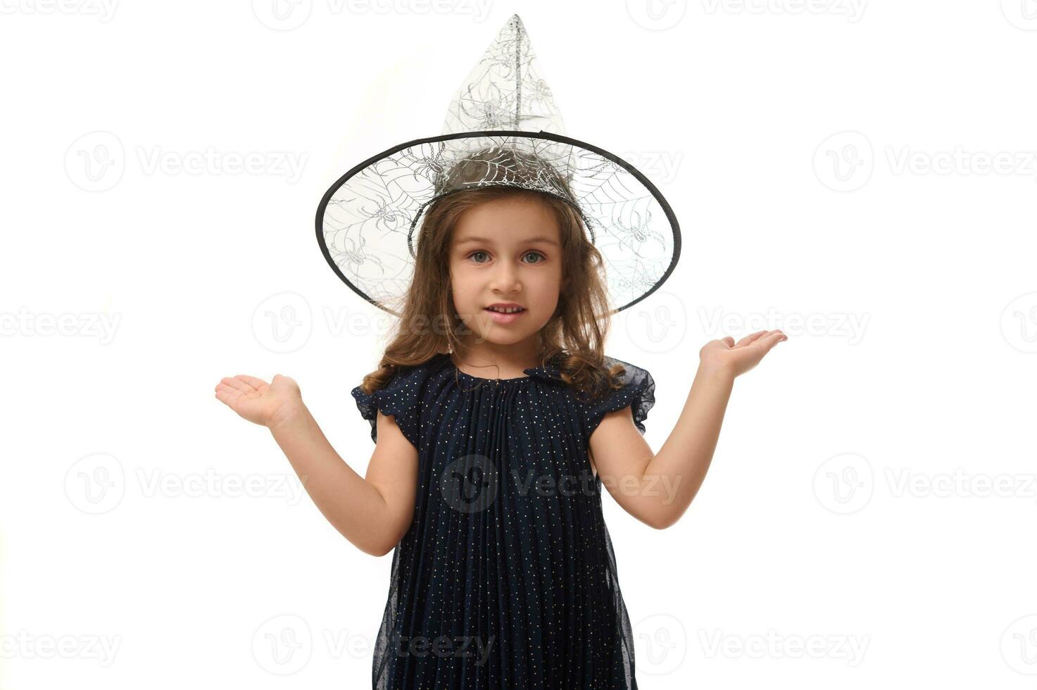 isolado retrato do bonita pequeno bruxa menina vestindo Mago chapéu, vestido dentro à moda carnaval vestir, gesticulando, segurando uma cópia de espaço imaginário em a Palma para inserir a anúncio. dia das Bruxas conceito foto