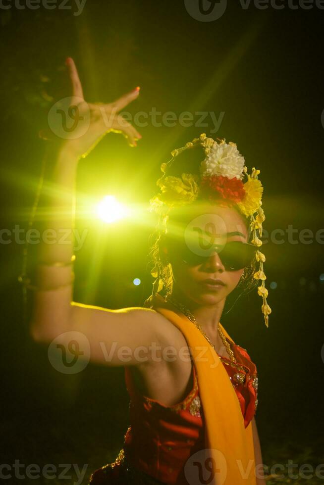 uma javanese dançarino danças muito habilmente enquanto vestindo oculos de sol em dela olhos e muito lindo facial Maquiagem foto