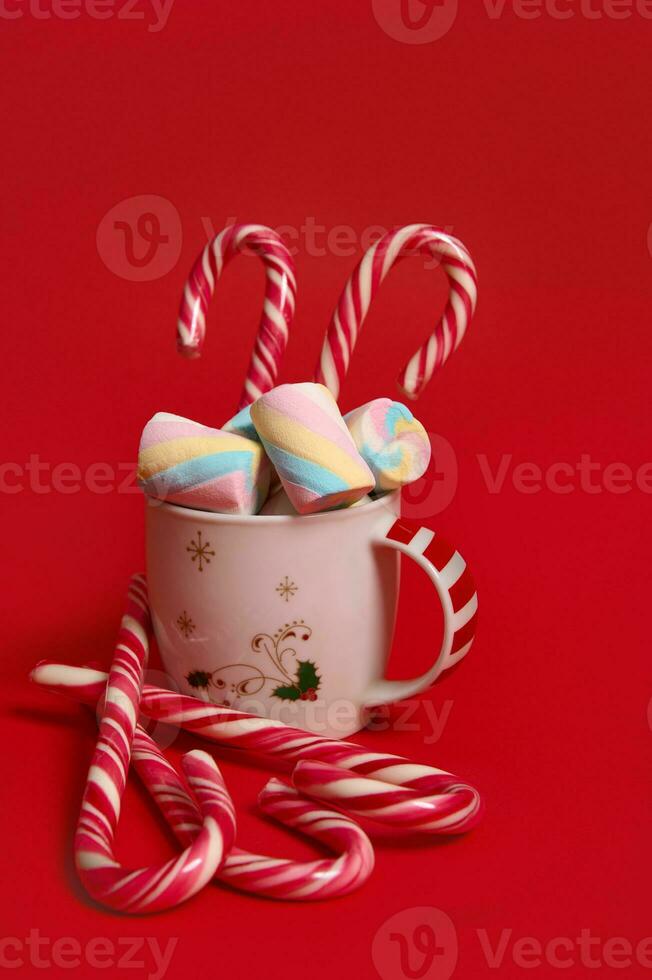 Natal composição com quente chocolate decorado com marshmellows e doce bengalas isolado sobre vermelho colori Backgroud com cópia de espaço para de Anúncios foto