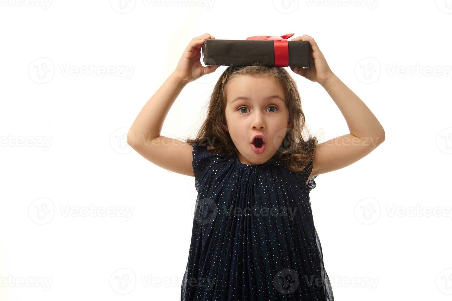 aniversário, Preto Sexta-feira conceito. isolado retrato em branco fundo, cópia de espaço do surpreso pequeno menina dentro tarde vestir segurando uma Preto presente caixa com vermelho fita em dela cabeça, olhando às Câmera foto