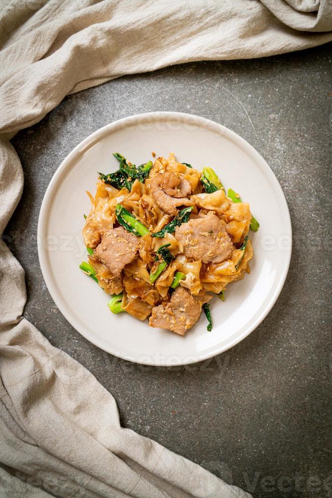 macarrão de arroz frito com molho de soja preto e carne de porco e couve foto