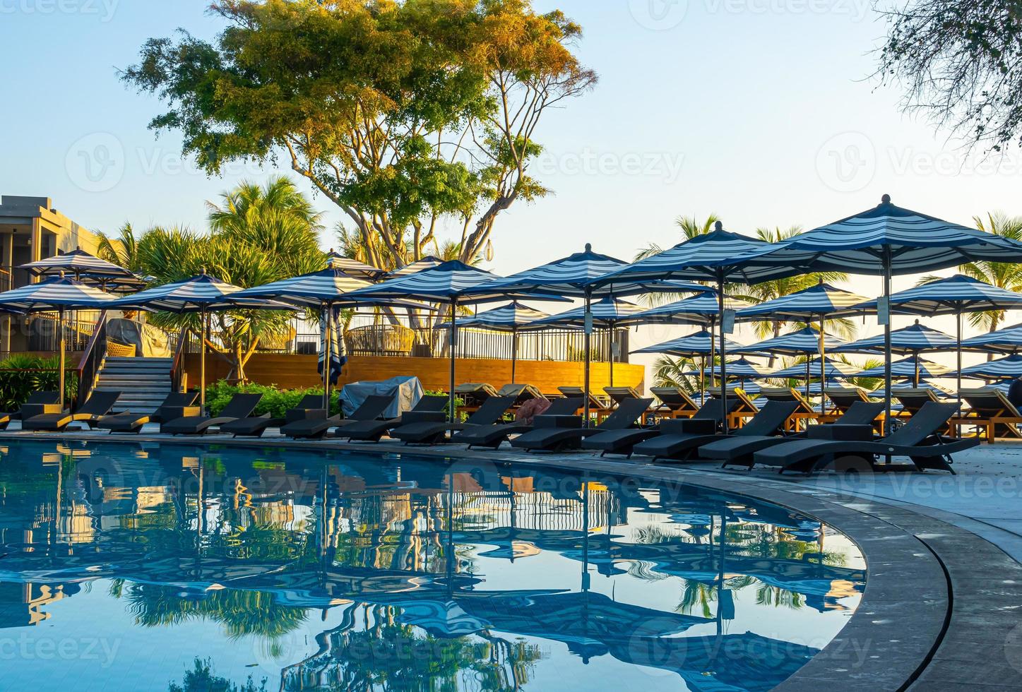 guarda-sol e cama ao redor da piscina externa em hotel resort para viagens de férias foto