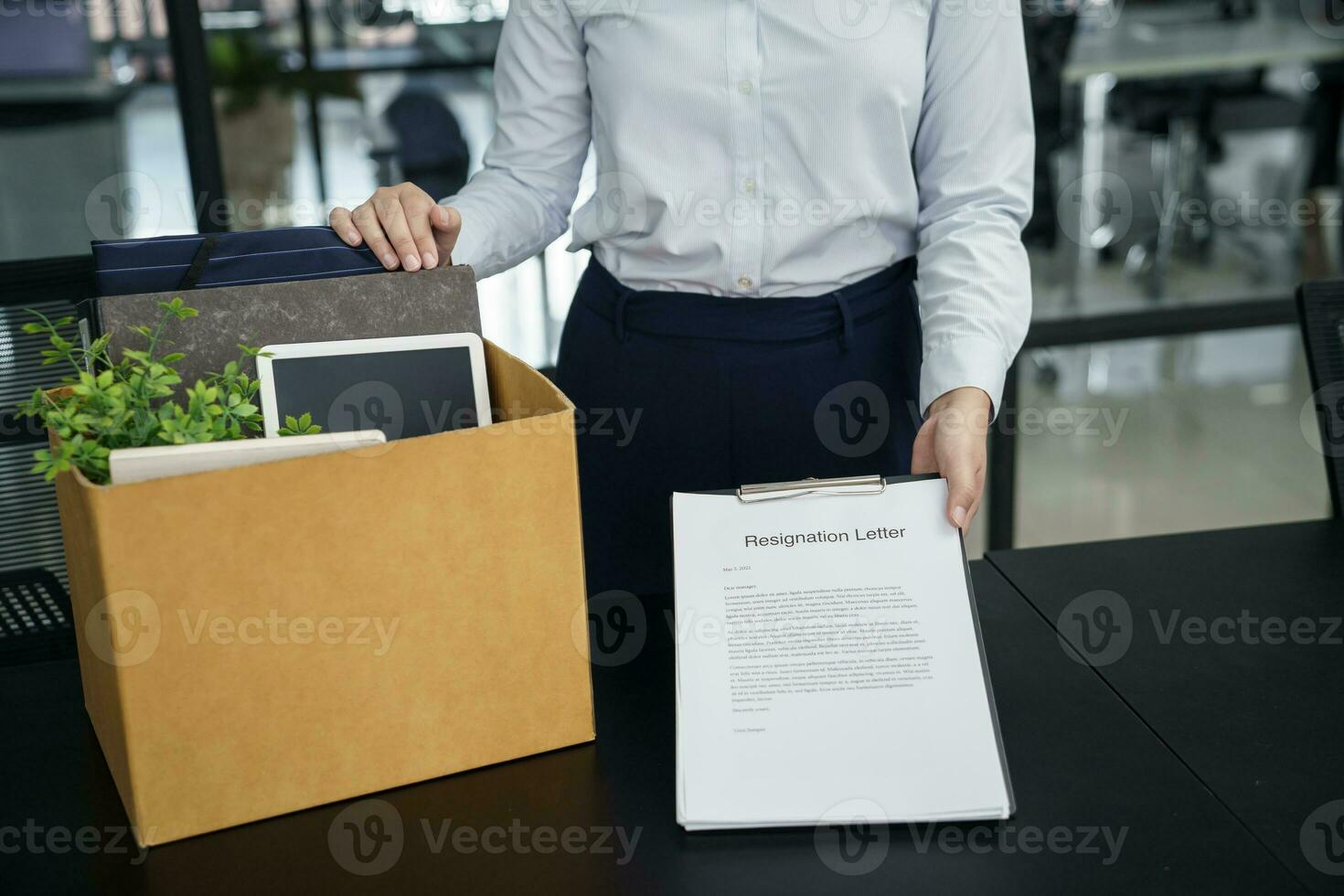 o negócio mulher enviando renúncia carta para patrão e segurando coisa demitir-se deprimir ou carregando cartão caixa de escrivaninha dentro escritório foto