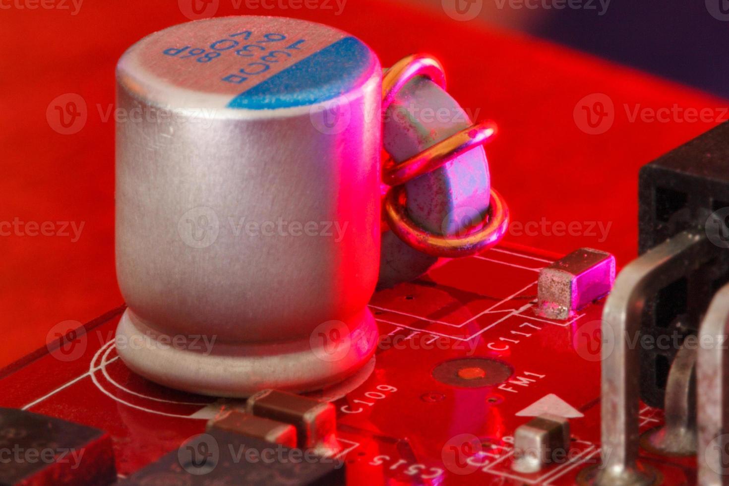 placa de circuito impresso eletrônico com componentes eletrônicos em vermelho foto