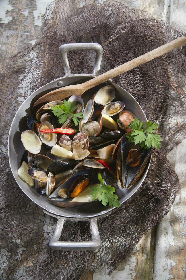 uma panela preenchidas com mexilhões e de outros frutos do mar foto