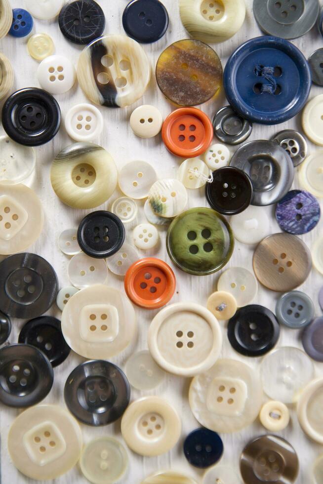 uma pilha do botões em uma branco mesa foto