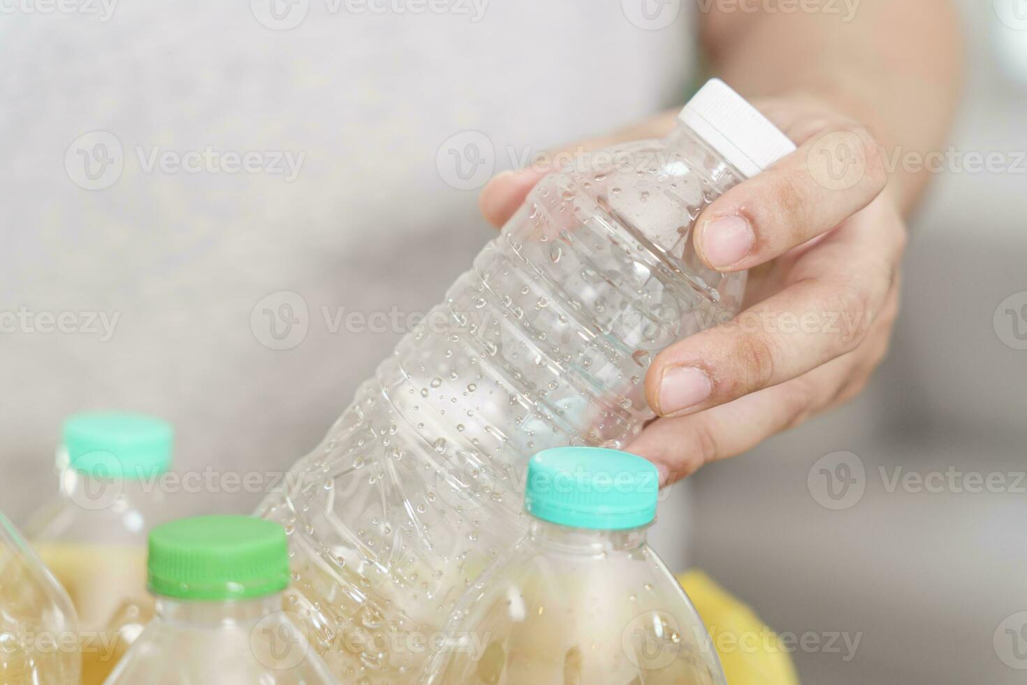 casa reciclar eco verde zero conceito homem jogando esvaziar plástico garrafa dentro reciclando bin com amarelo lixo bolsas às casa foto