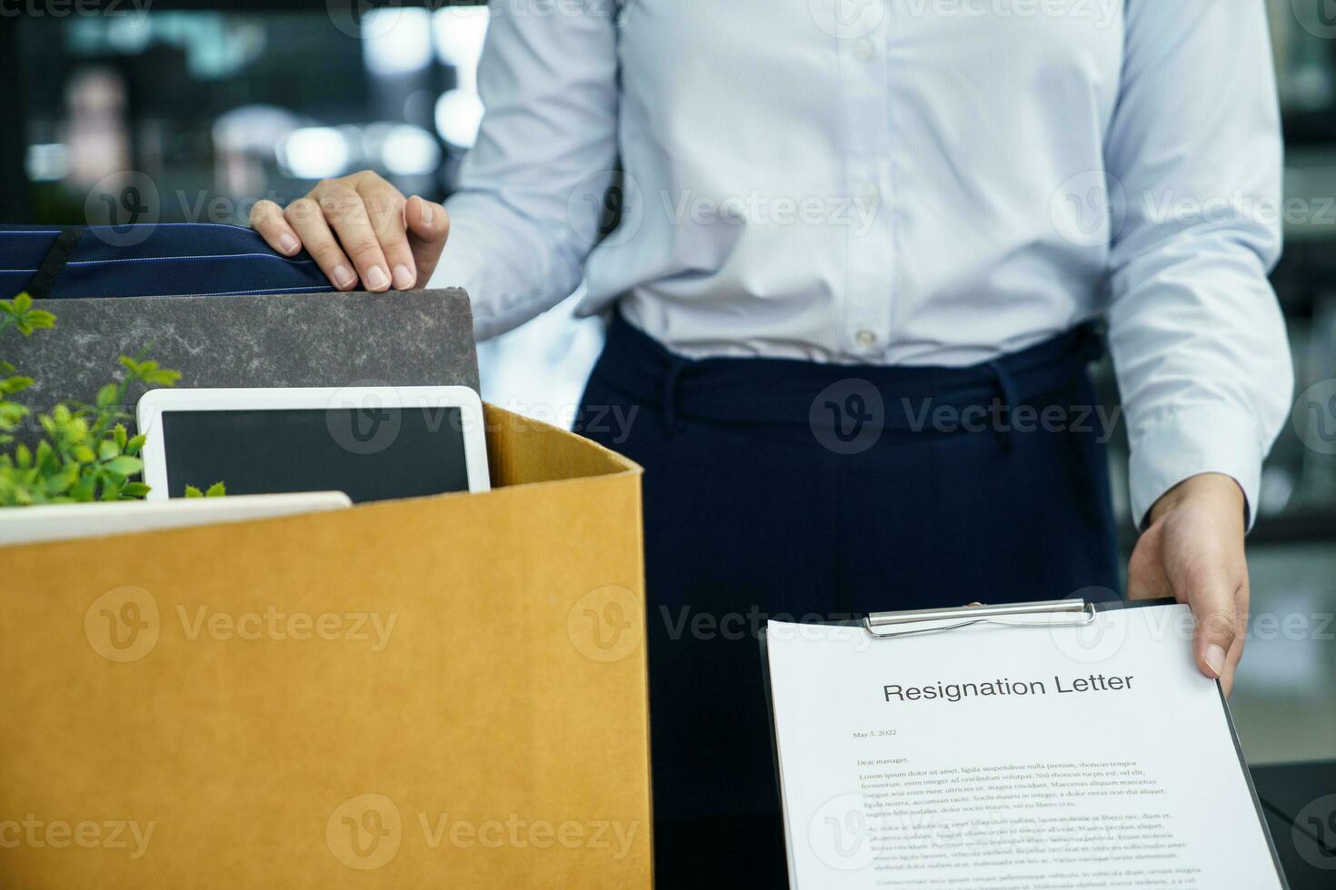 o negócio mulher enviando renúncia carta para patrão e segurando coisa demitir-se deprimir ou carregando cartão caixa de escrivaninha dentro escritório foto