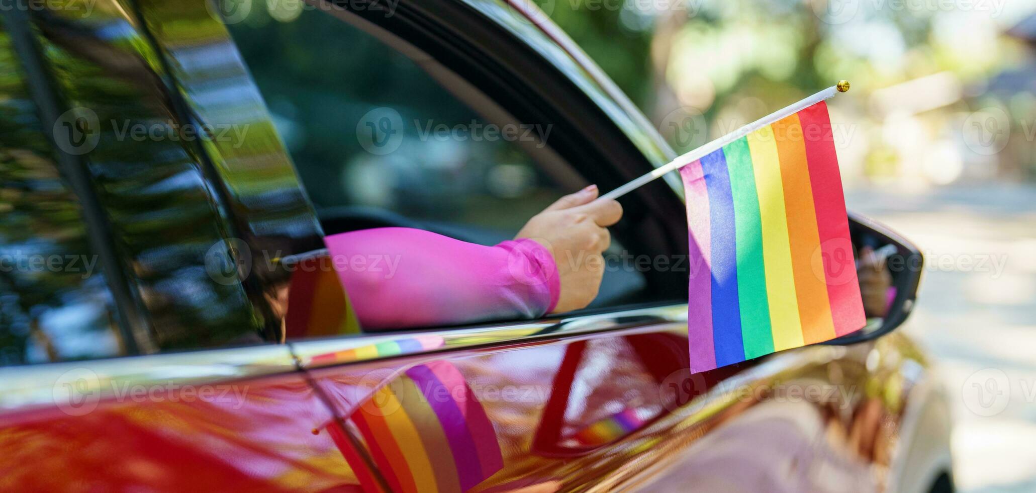 feliz ásia mulher Apoio, suporte lgbt orgulho parada dentro carro. com arco Iris do lgbtq ou lgbtqia. foto