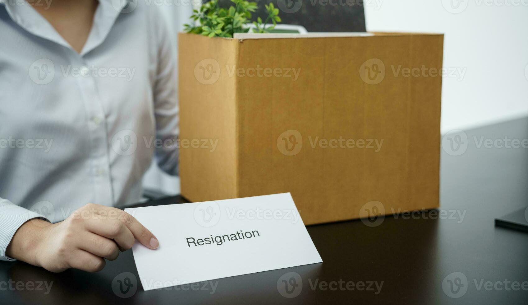 o negócio mulher enviando renúncia carta para patrão e segurando coisa demitir-se deprimir ou carregando cartão caixa de escrivaninha dentro escritório foto