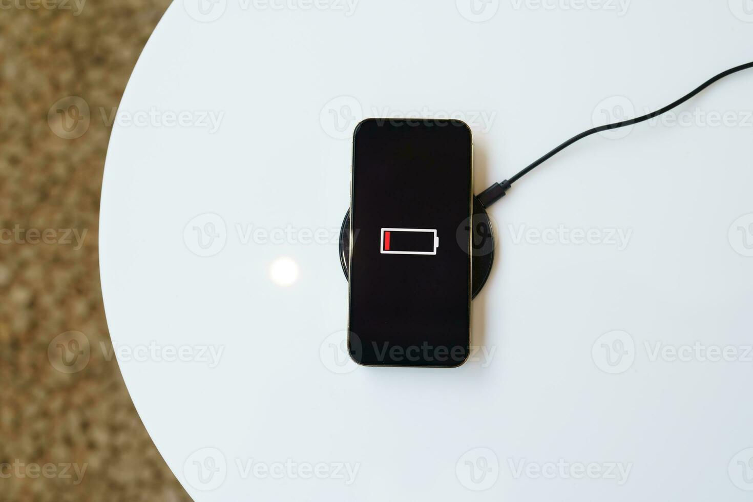 cobrando Móvel telefone bateria com sem fio cobrando dispositivo dentro a mesa. Smartphone cobrando em uma cobrando almofada. Móvel telefone perto sem fio carregador moderno estilo de vida tecnologia conceito. foto