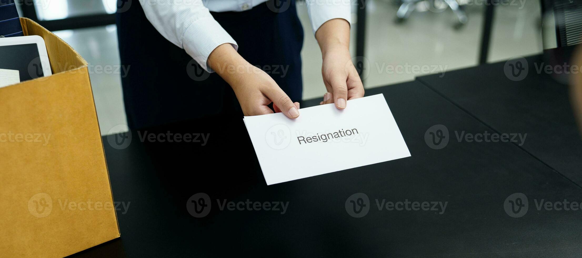 o negócio mulher enviando renúncia carta para patrão e segurando coisa demitir-se deprimir ou carregando cartão caixa de escrivaninha dentro escritório foto