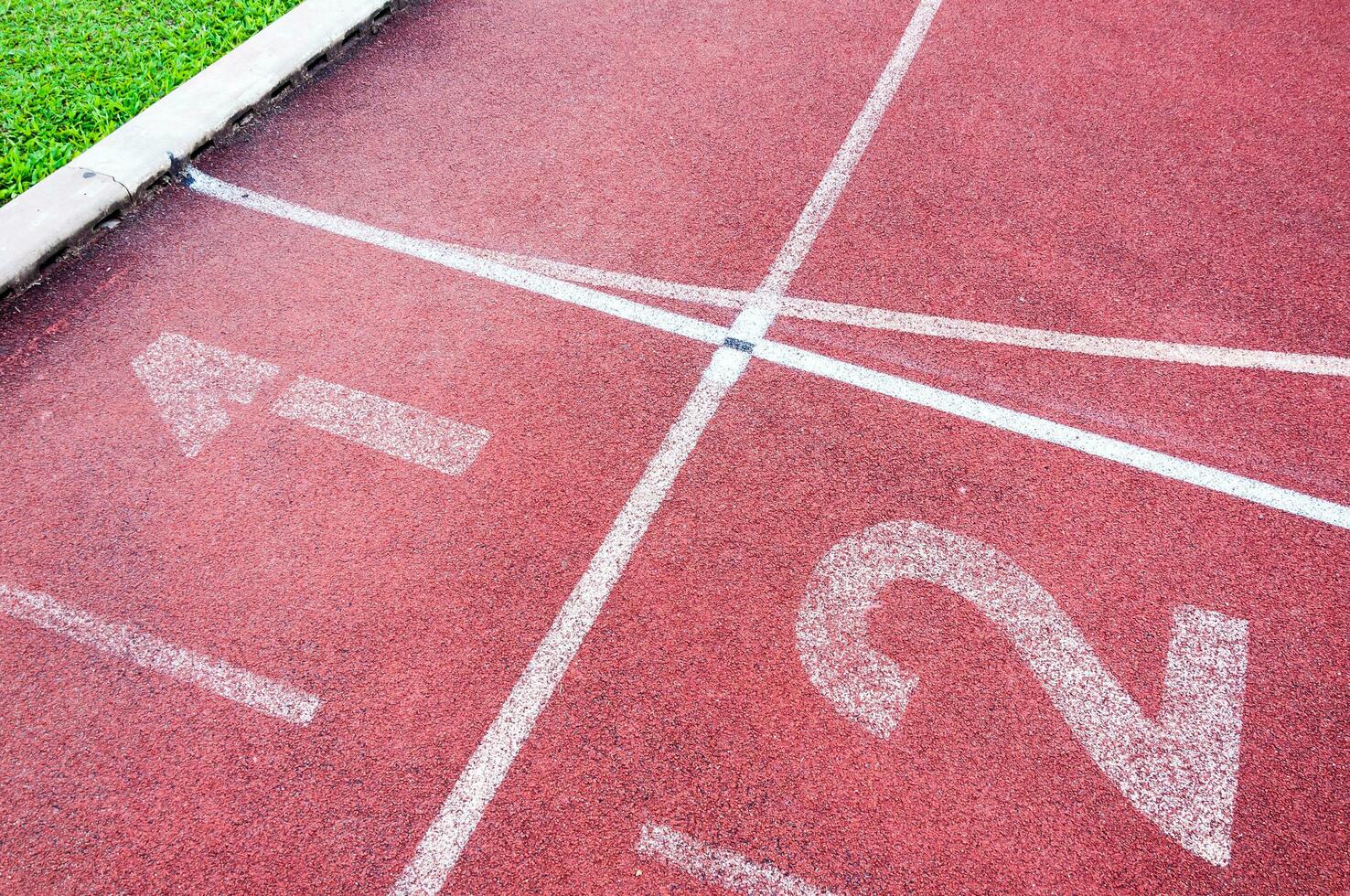 números iniciando ponto em vermelho corrida rastrear, correr rastrear e verde grama, direto atletismo corrida rastrear às esporte estádio foto